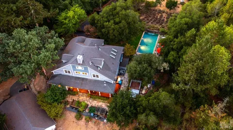 an aerial view of a house with a yard and large trees