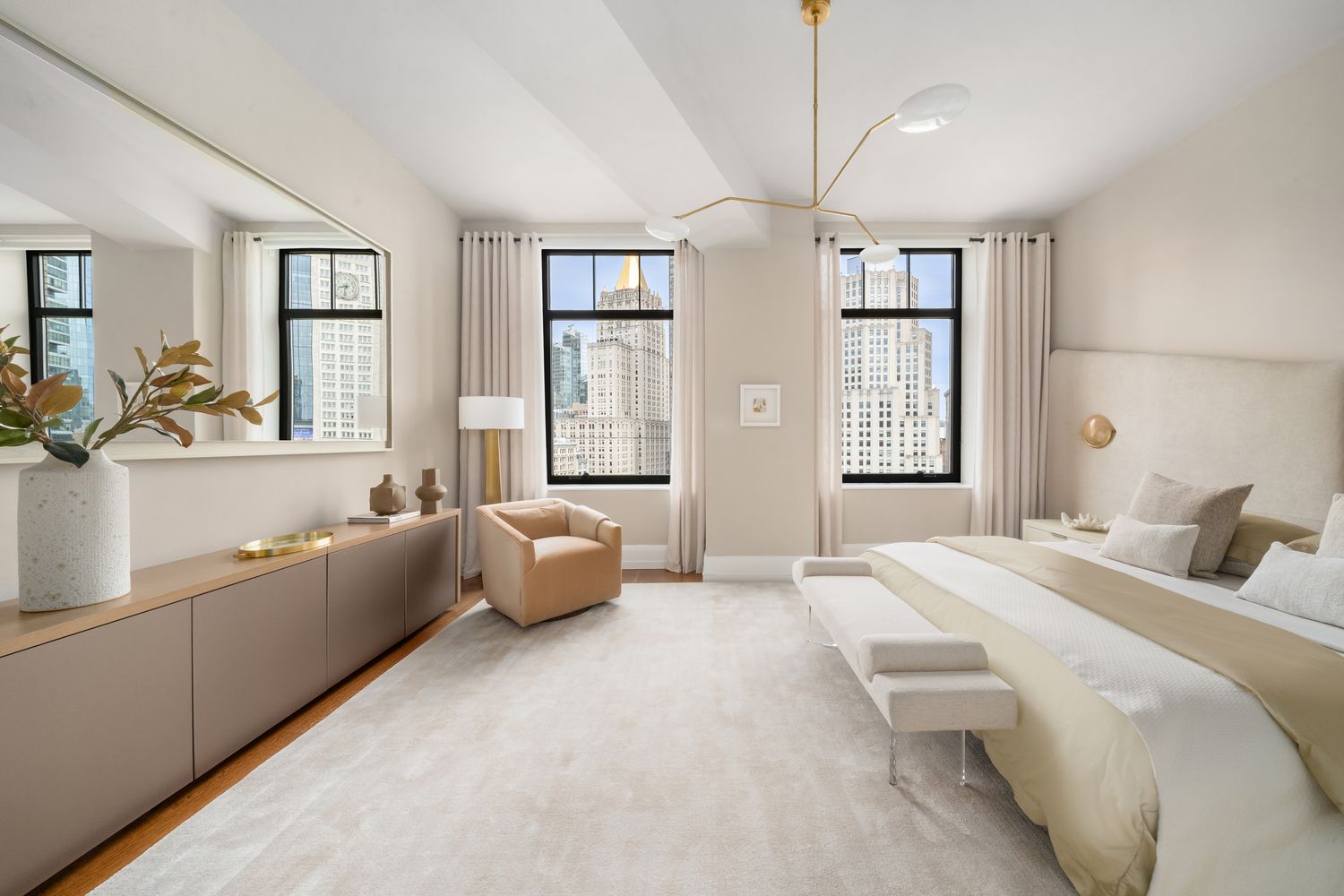 a spacious bedroom with a bed couch and windows