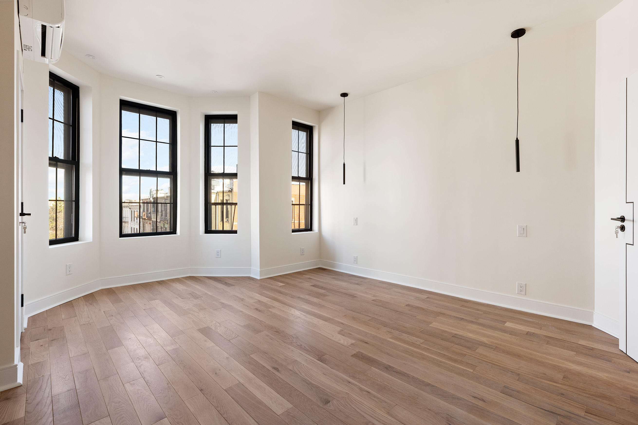 152 North 10th Street, Unit 1R Brooklyn, NY 11249 - Photo 12 of 18 a view of an empty room with window and wooden floor