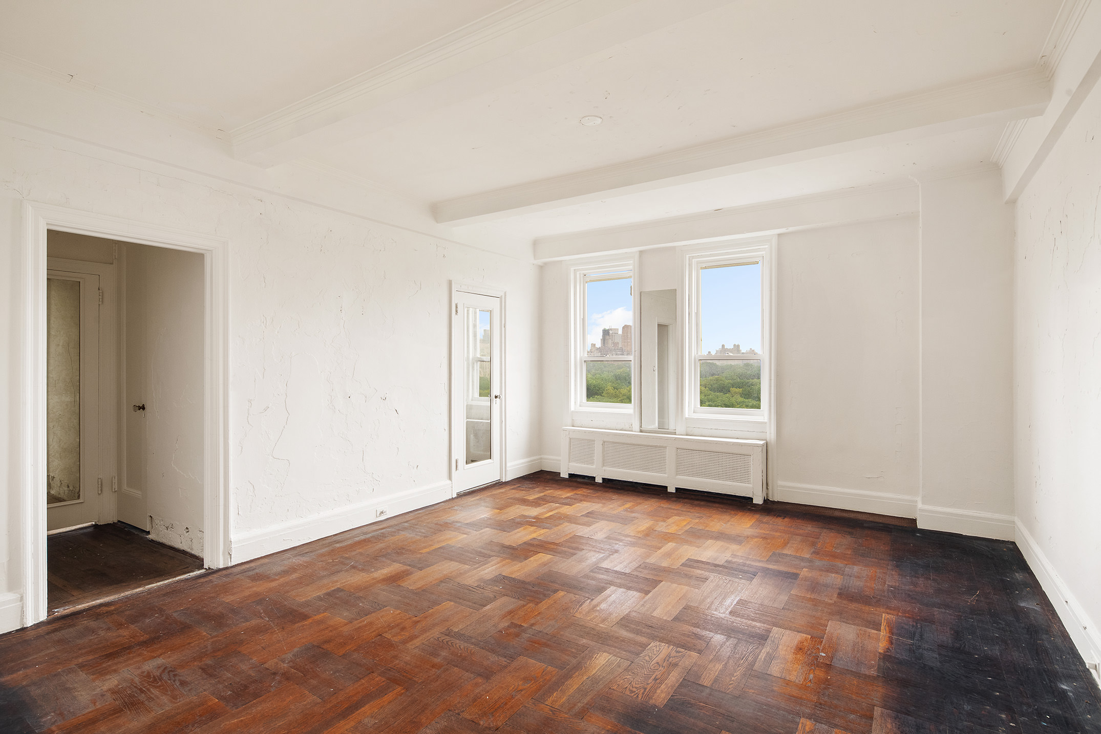 128 Central Park South, Unit 13A Manhattan, NY 10019 - Photo 3 of 10 an empty room with wooden floor and windows