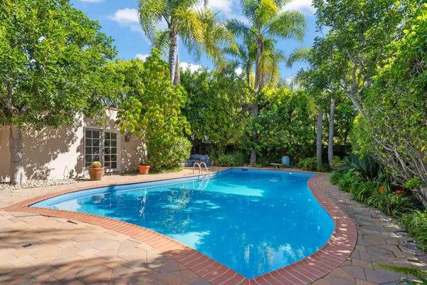 a view of a house with pool yard and sitting area