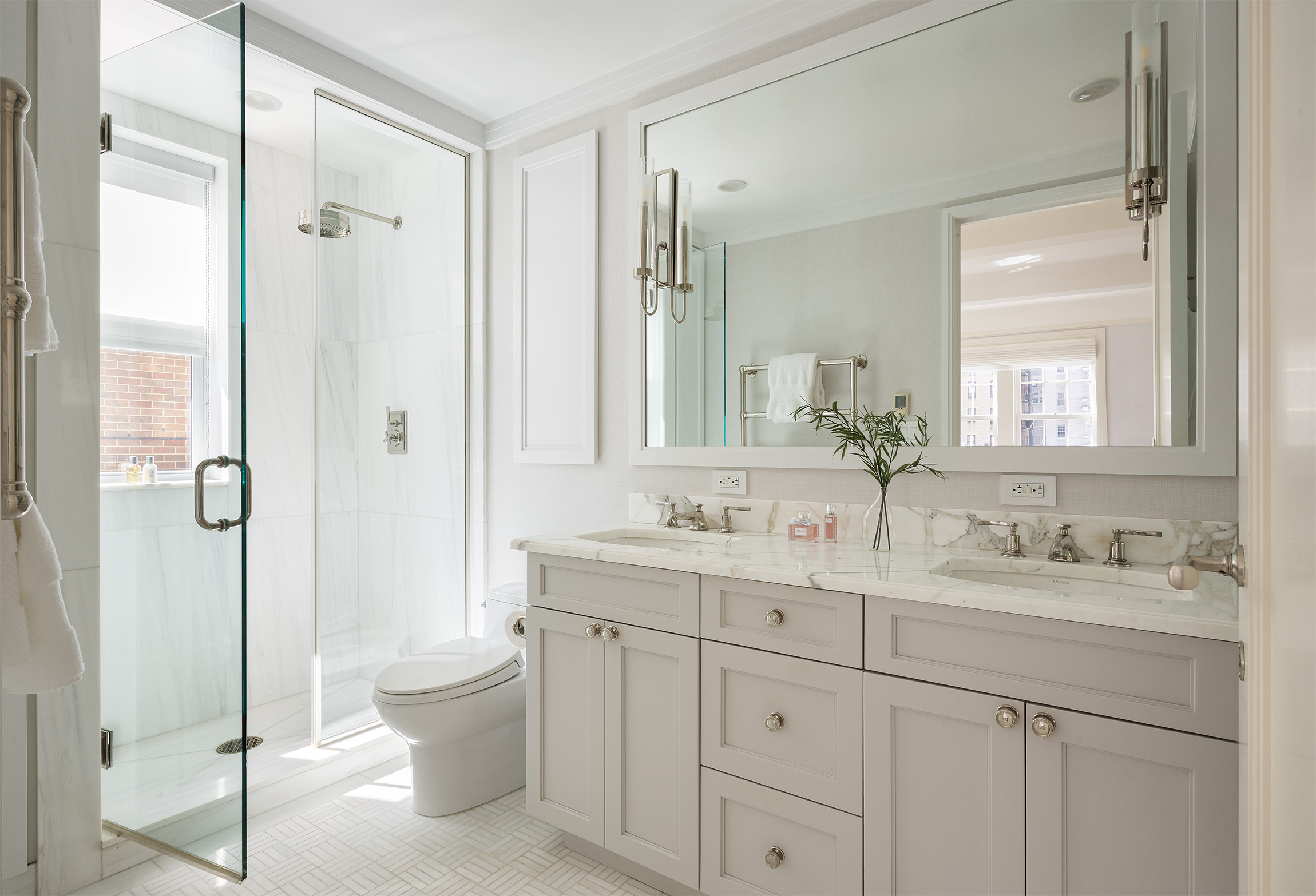 40 East 66th Street, Unit 9A Manhattan, NY 10065 - Photo 8 of 14 a bathroom with a double vanity sink toilet mirror and shower