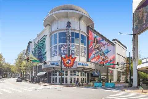 a front view of multi story residential apartment building with retail shops