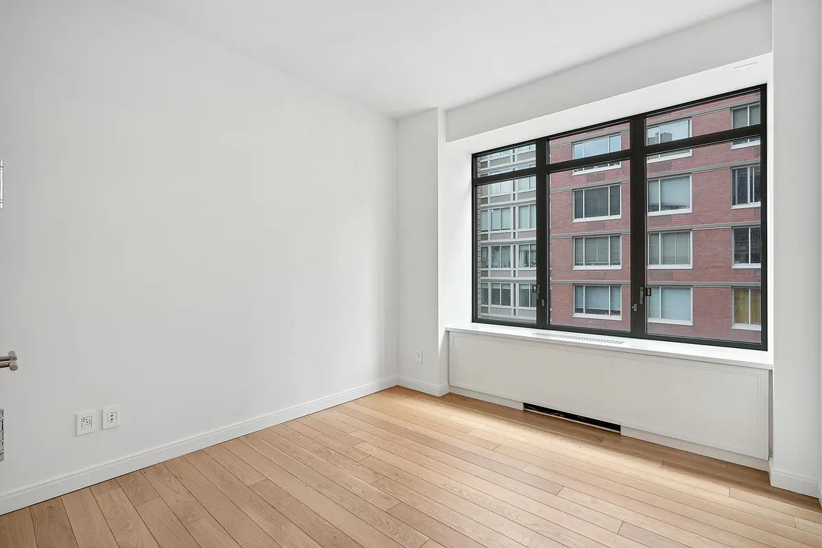 269 West 87th Street, Unit 7B Manhattan, NY 10024 - Photo 10 of 21 an empty room with wooden floor and windows