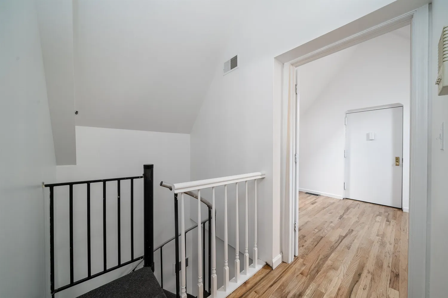 a view of a hallway with wooden floor