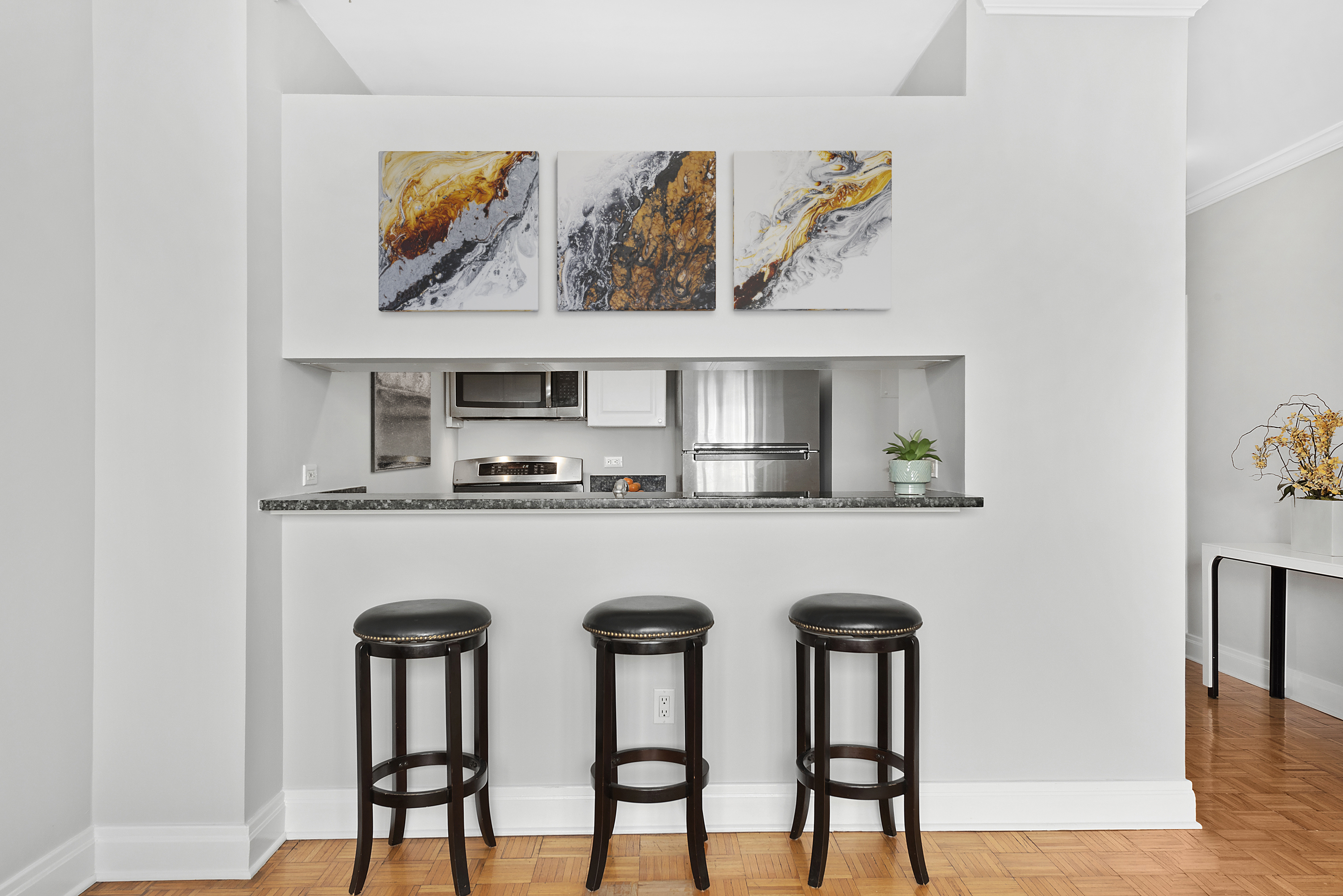 400 East 90th Street, Unit 8E Manhattan, NY 10128 - Photo 2 of 6 a kitchen with stainless steel appliances granite countertop a table and chairs in it
