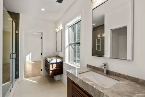 a en suite bathroom with a granite countertop sink and a mirror