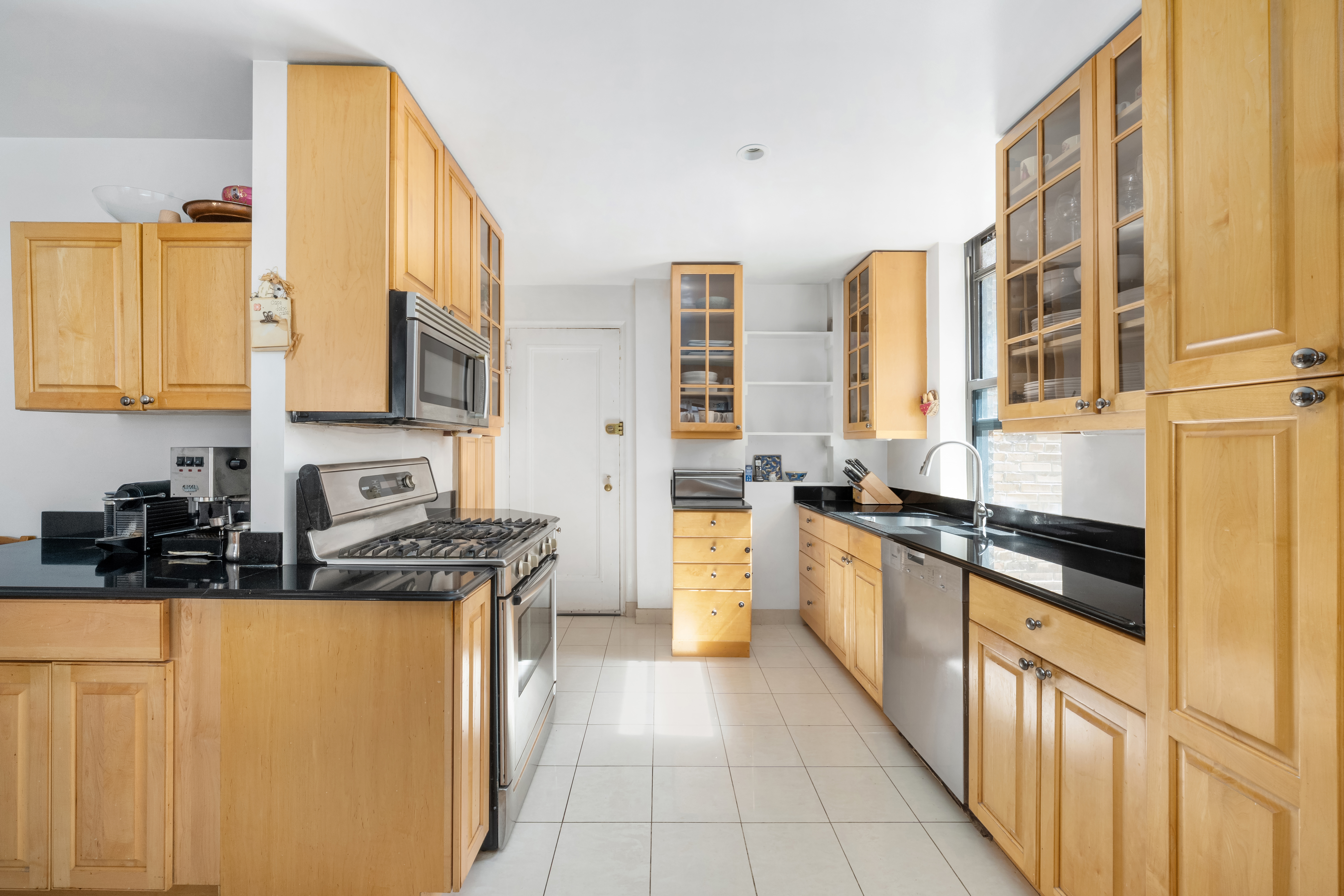 514 West End Avenue, Unit 12BC Manhattan, NY 10024 - Photo 6 of 15 a kitchen with stainless steel appliances granite countertop a stove a sink and a refrigerator