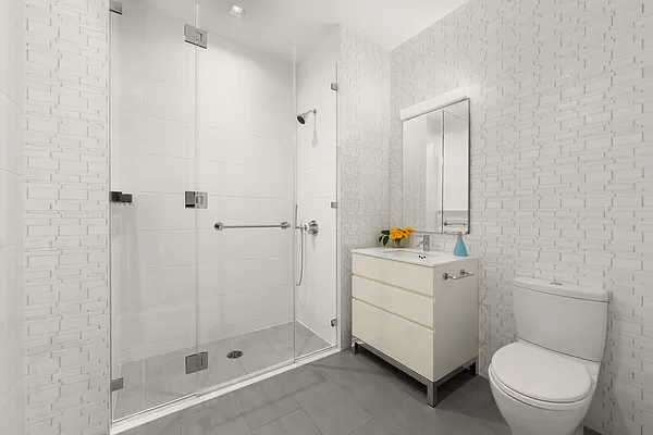 252 East 57th Street, Unit 62B Manhattan, NY 10022 - Photo 11 of 15 a bathroom with a sink a toilet and shower