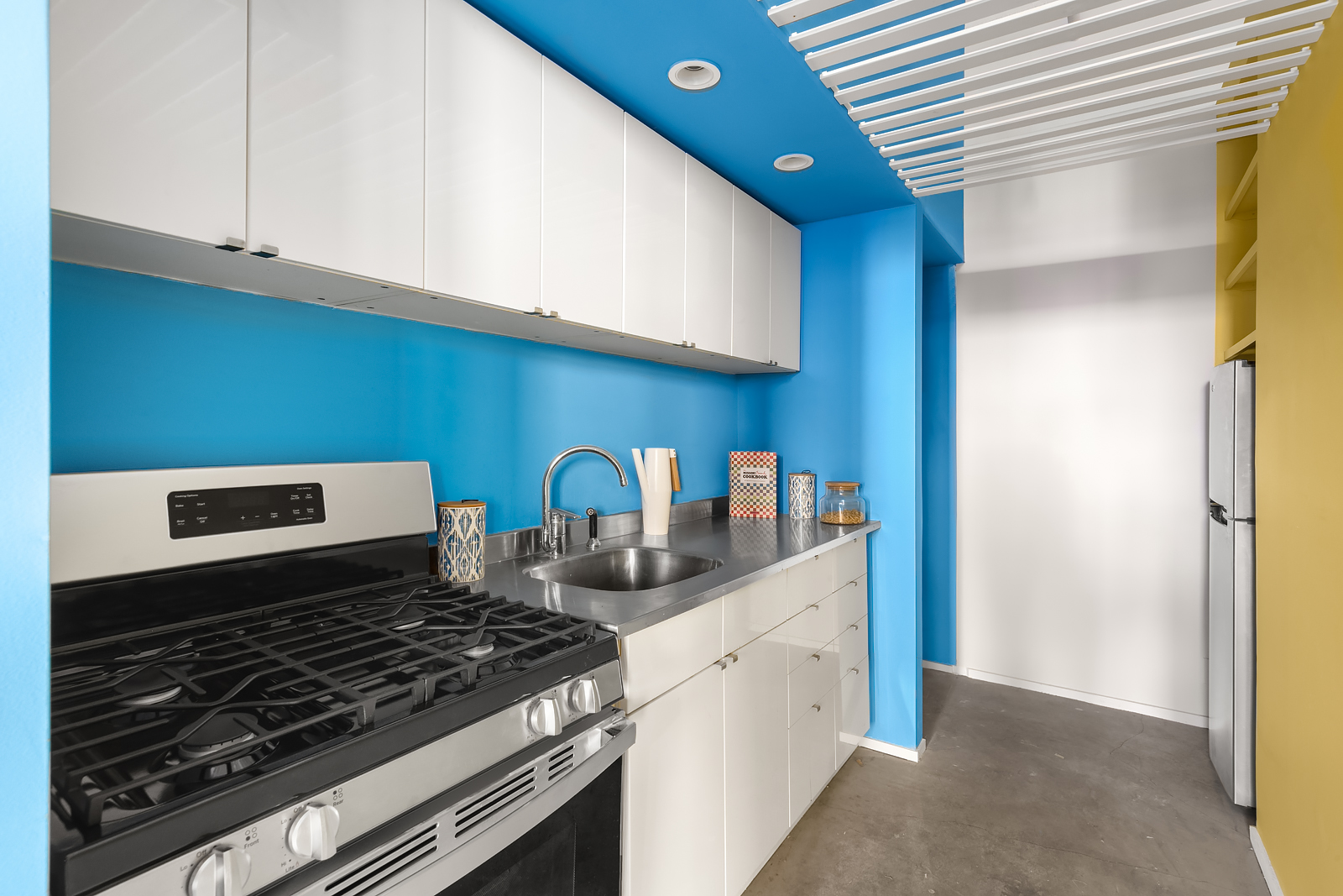 448 West 37th Street, Unit 12F Manhattan, NY 10018 - Photo 9 of 11 a kitchen with stainless steel appliances granite countertop a stove and a white cabinets