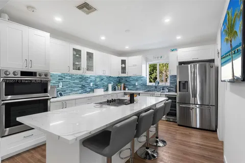 a large kitchen with stainless steel appliances lots of counter space and wooden floor