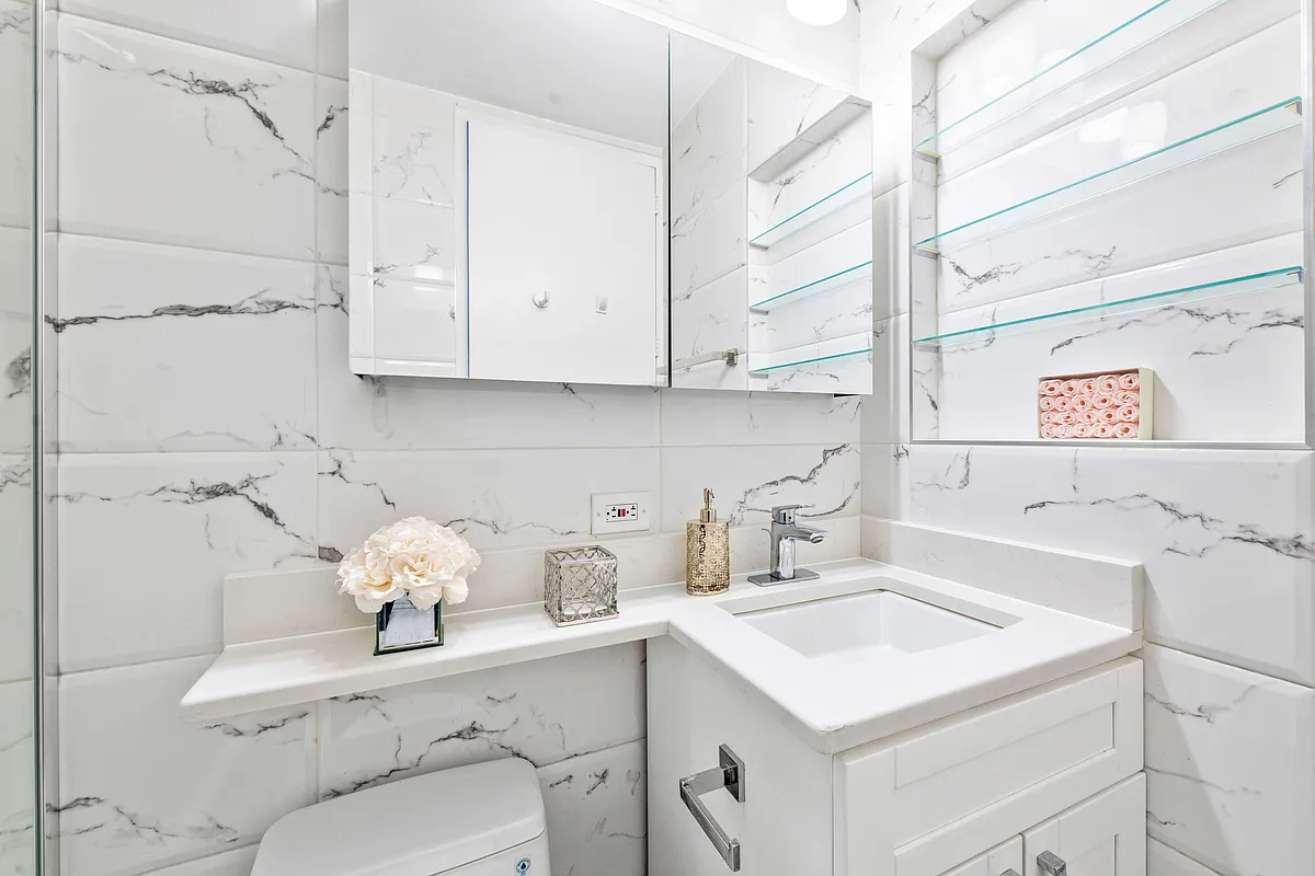 300 East 62nd Street, Unit 1001 Manhattan, NY 10065 - Photo 7 of 10 a kitchen with a sink a stove and cabinets