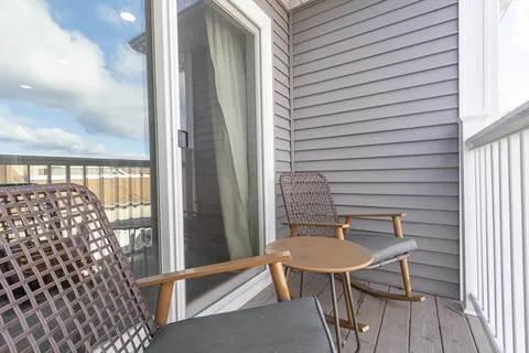 a balcony with table and chairs