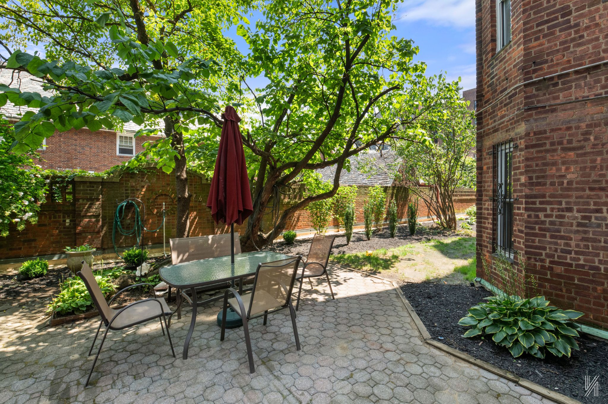 34-41 85th Street, Unit 1U Queens, NY 11372 - Photo 20 of 24 a view of a patio with table and chairs potted plants and large tree