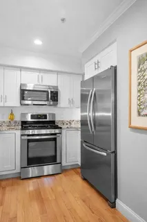a kitchen with granite countertop a stainless steel appliances and wooden floor