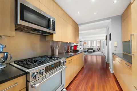 a kitchen with a stove a microwave and wooden floor