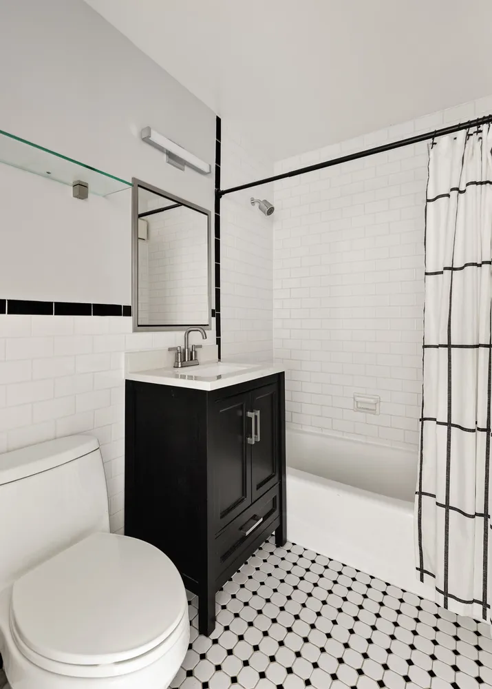 a bathroom with a sink a toilet a shower and a mirror