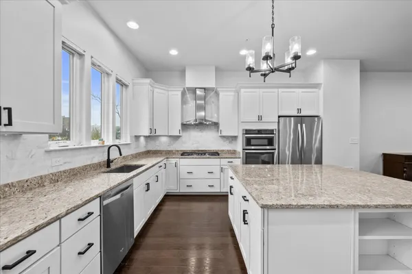 a kitchen with kitchen island granite countertop a sink counter top space stainless steel appliances and cabinets