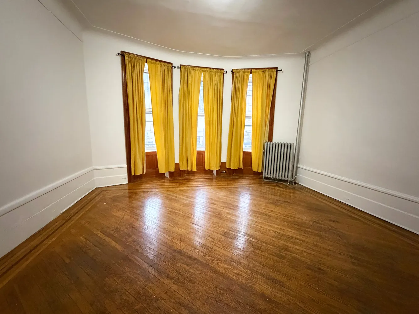a view of room with floor to ceiling window and wooden floor