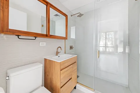 a bathroom with a sink a mirror and shower