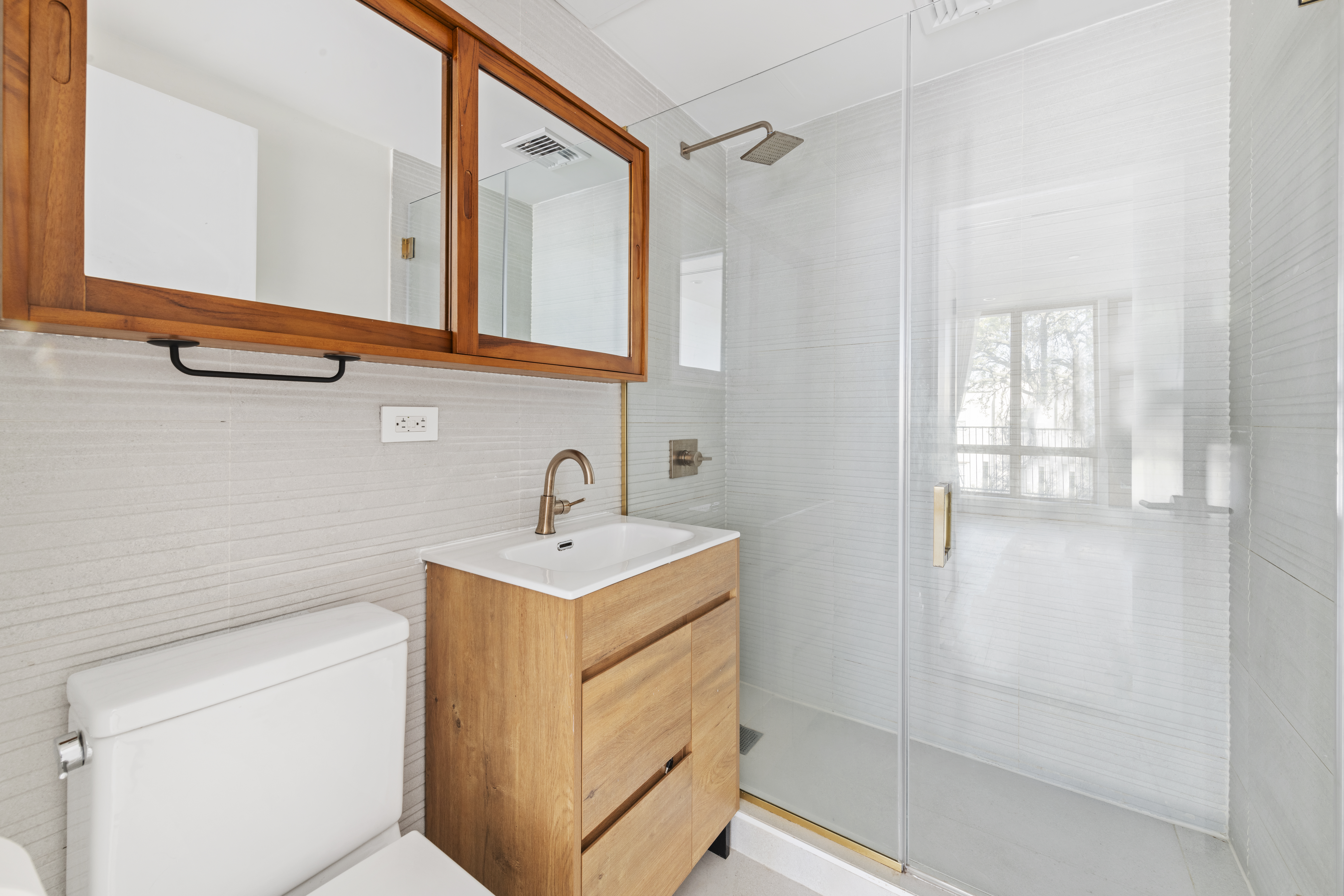 42 Rochester Avenue, Unit 3 Brooklyn, NY 11233 - Photo 10 of 18 a bathroom with a sink a mirror and shower