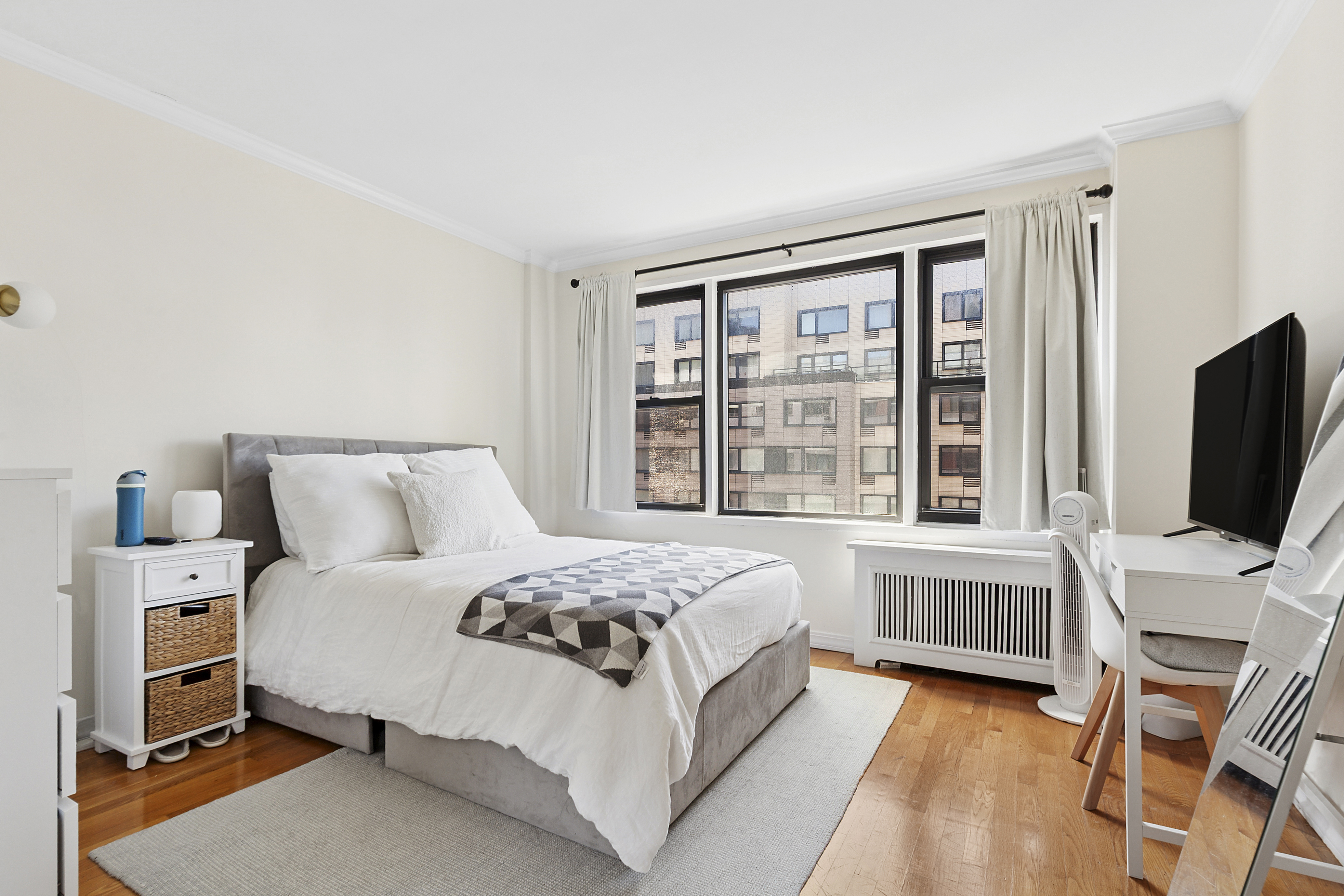 333 East 34th Street, Unit 14J Manhattan, NY 10016 - Photo 4 of 10 a bedroom with a large bed and a flat tv screen on a dresser