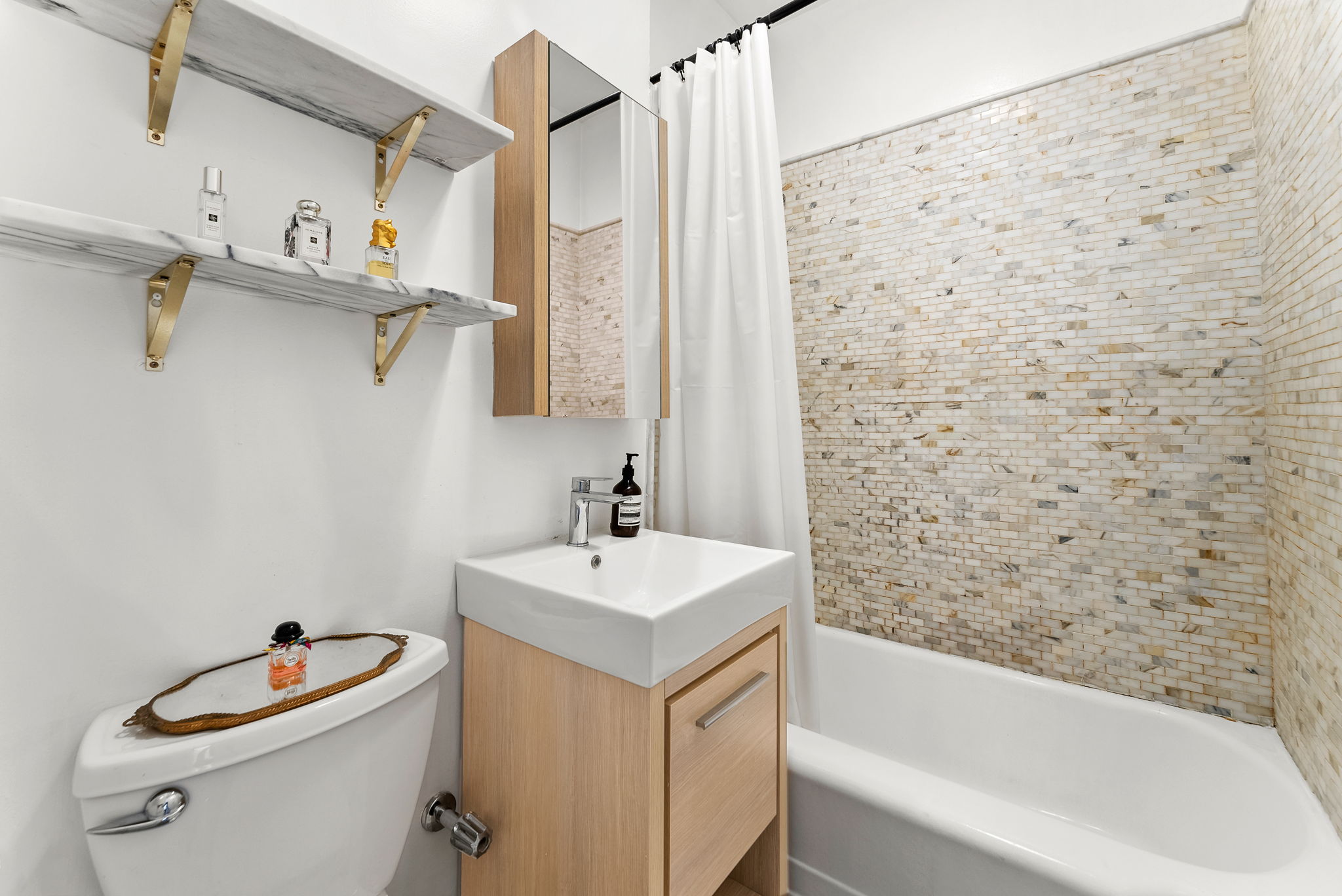 512 East 83rd Street, Unit D4 Manhattan, NY 10028 - Photo 14 of 21 a bathroom with a sink a toilet and shower