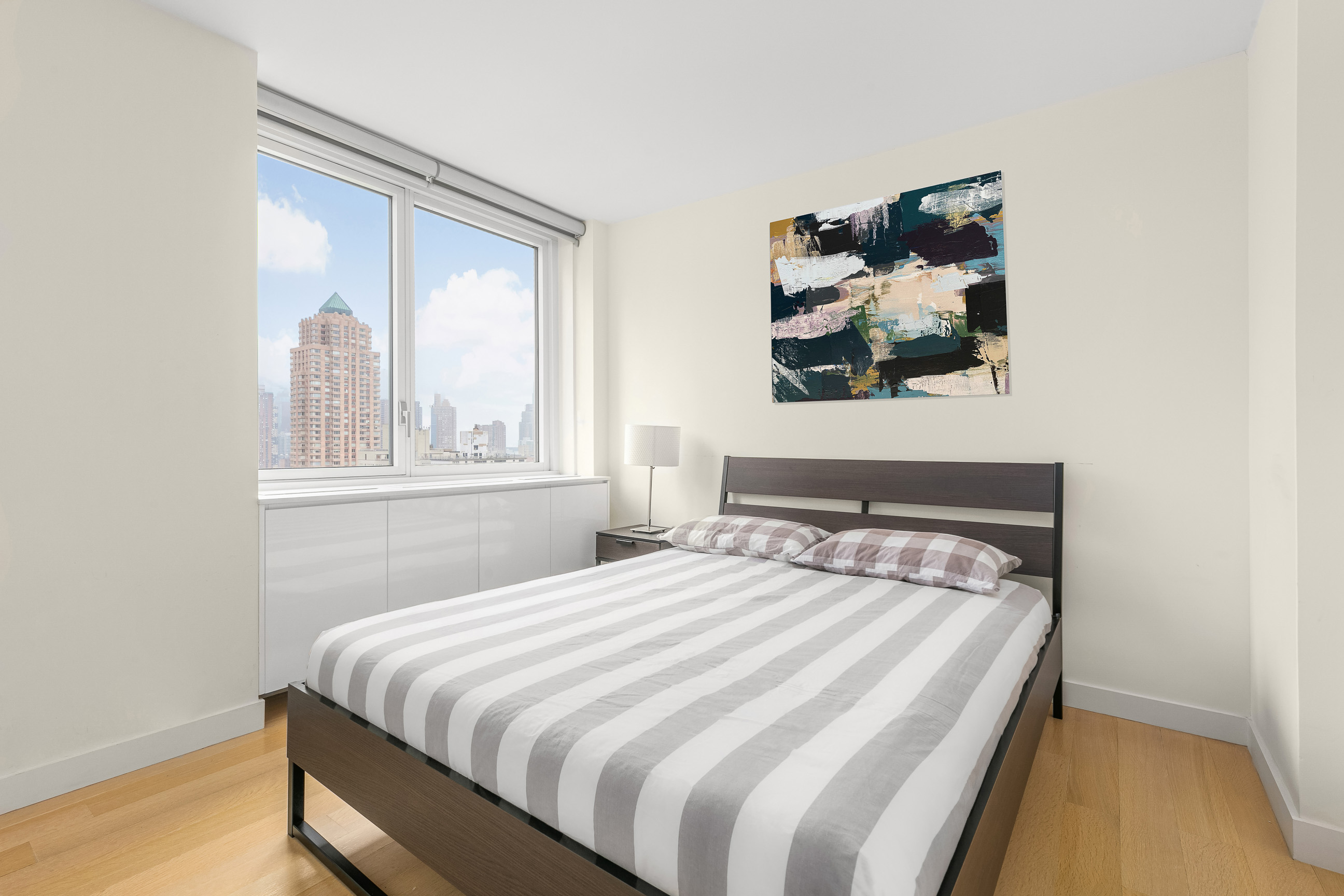 301 West 53rd Street, Unit 19K Manhattan, NY 10019 - Photo 5 of 8 a bedroom with a bed and a window