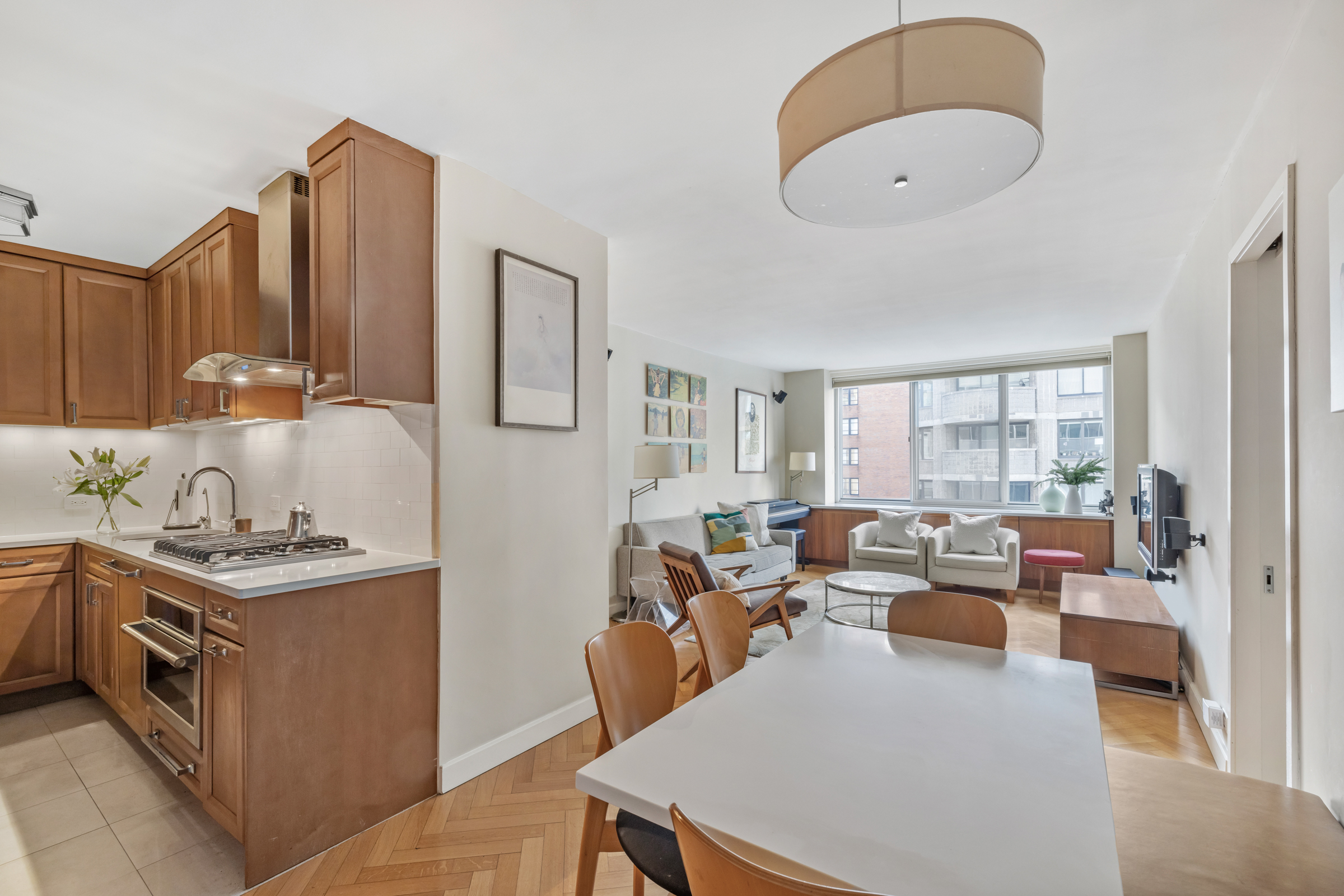 61 West 62nd Street, Unit 23G Manhattan, NY 10023 - Photo 4 of 9 a living room with furniture a flat screen tv and a large window