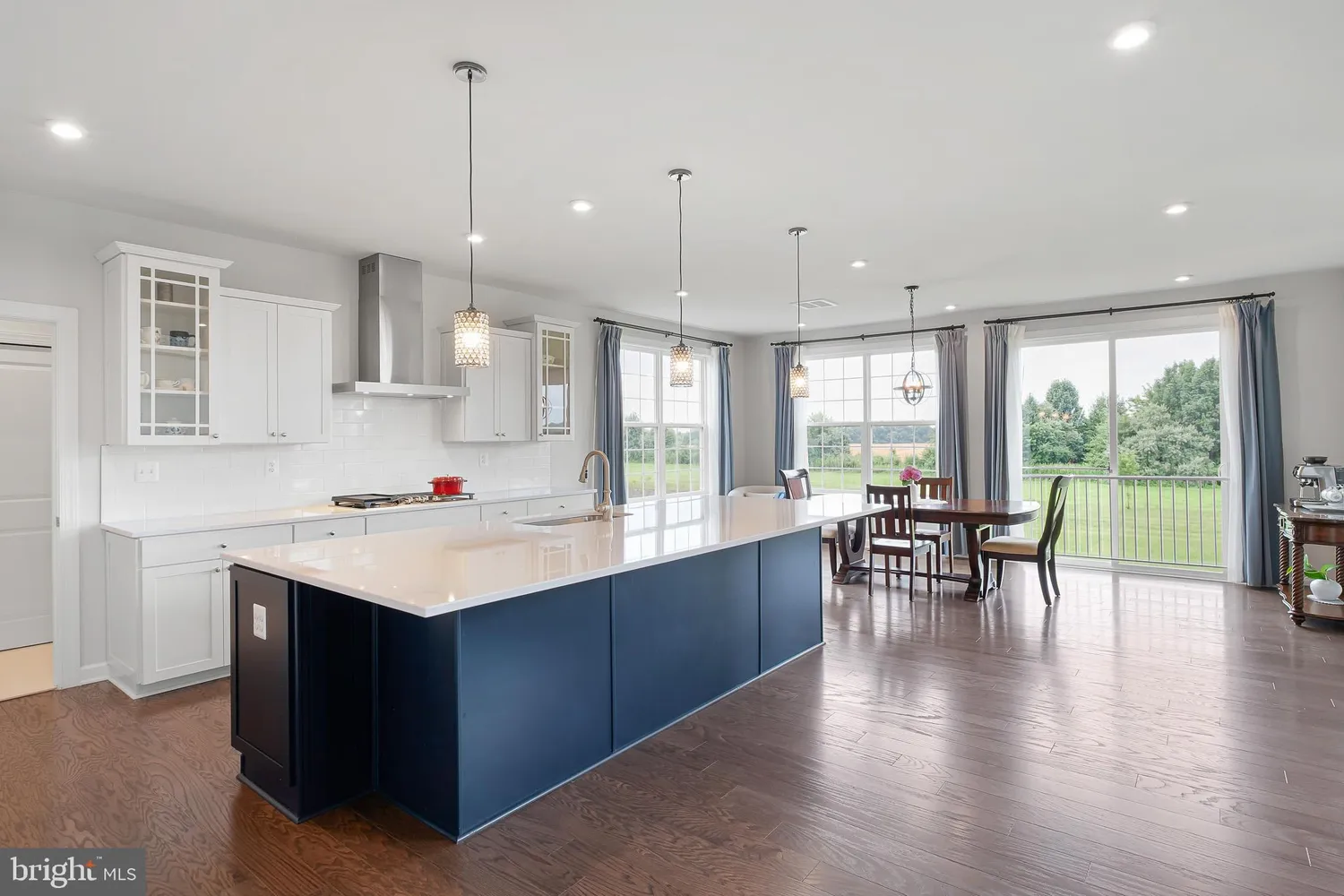 a kitchen with a sink a stove a dining table and chairs