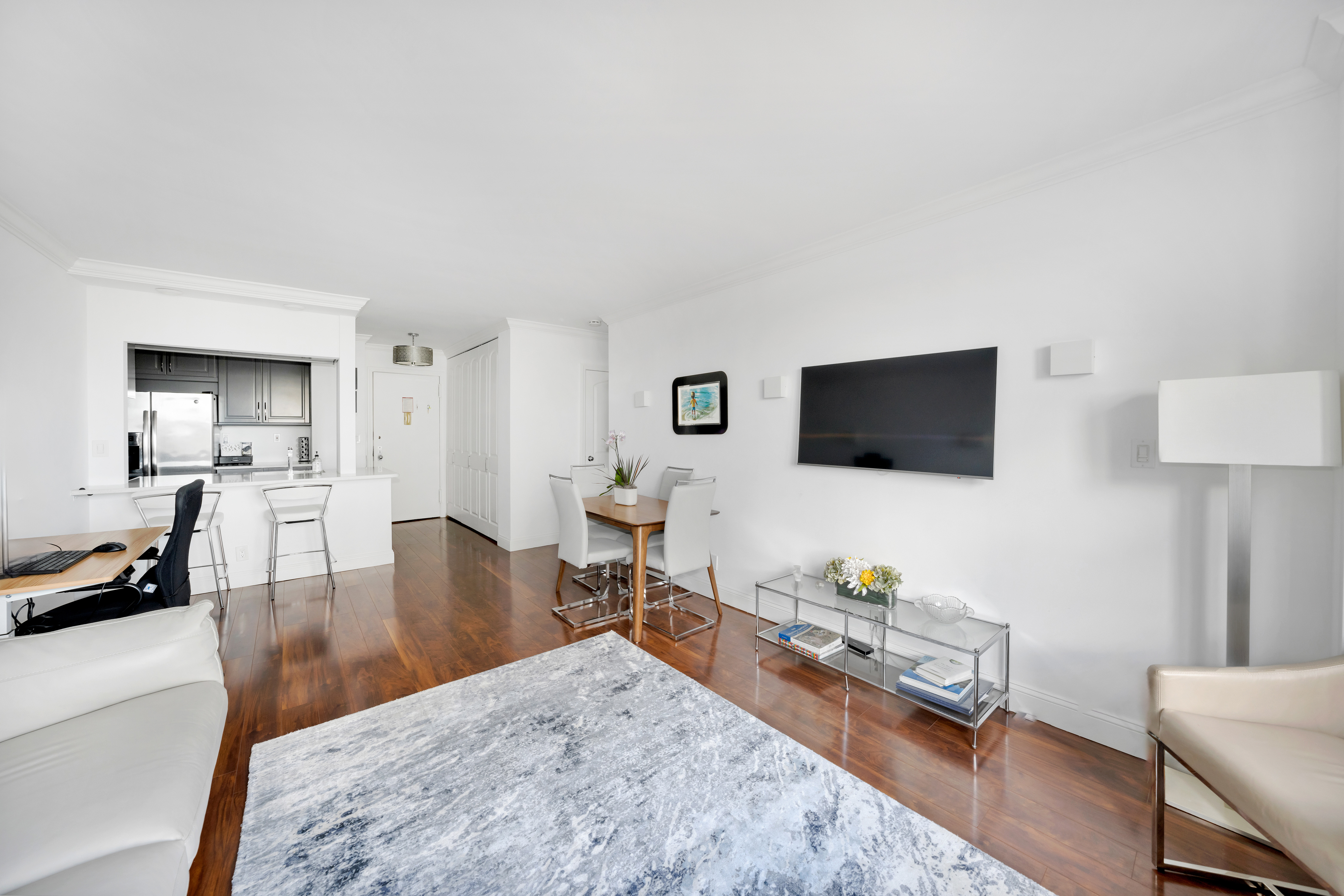 400 East 54th Street, Unit 26D Manhattan, NY 10022 - Photo 2 of 12 a living room with furniture and a flat screen tv
