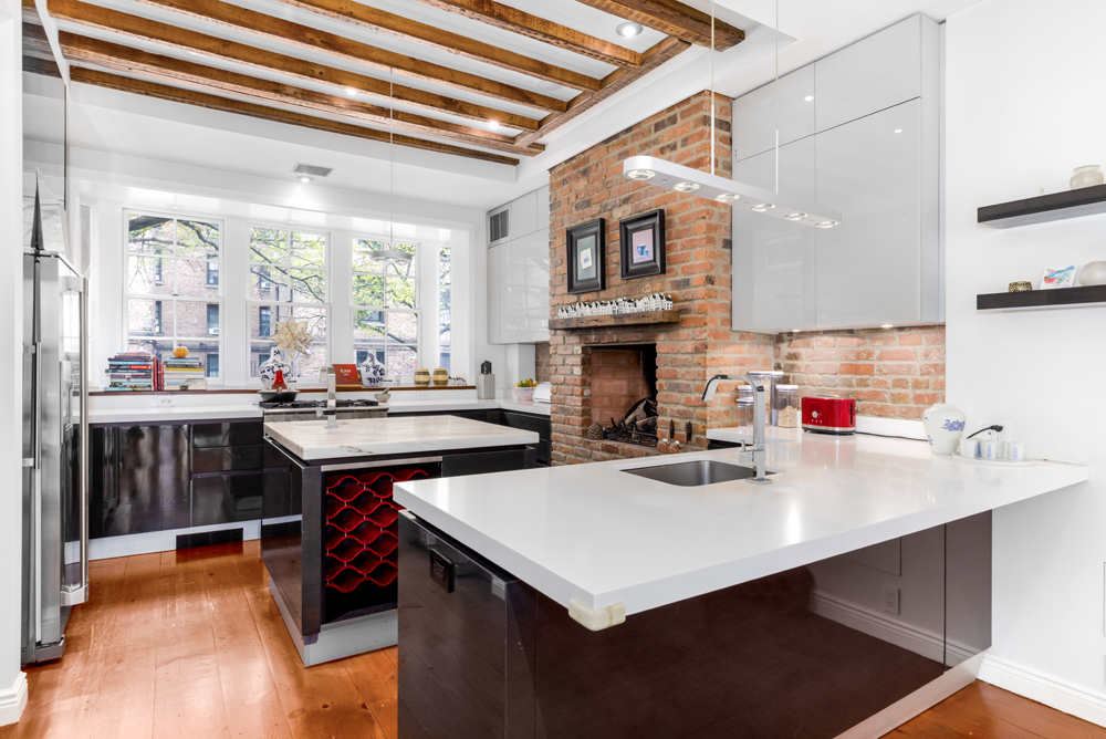 308 West 19th Street, Unit GARDEN Manhattan, NY 10011 - Photo 4 of 18 a kitchen with kitchen island a sink dishwasher a stove and a dining table with wooden floor