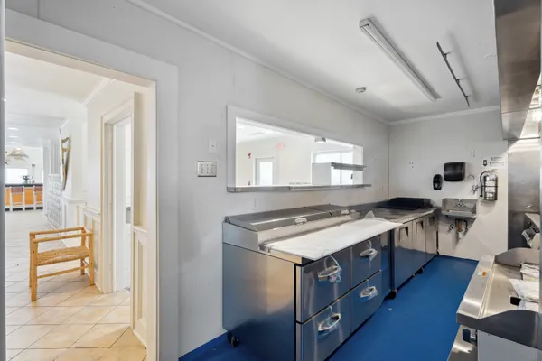 a kitchen with stainless steel appliances a stove a chimney a sink and cabinets