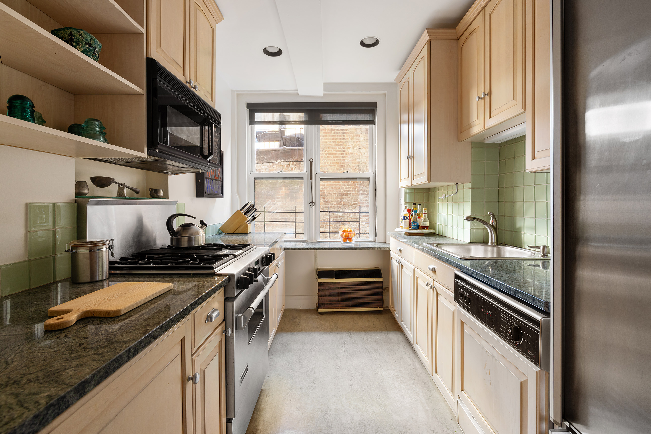 277 West End Avenue, Unit 5D Manhattan, NY 10023 - Photo 7 of 15 a kitchen with stainless steel appliances granite countertop a stove and a sink
