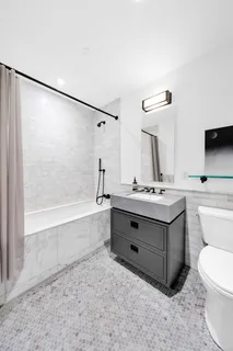 a bathroom with a tub sink toilet and mirror