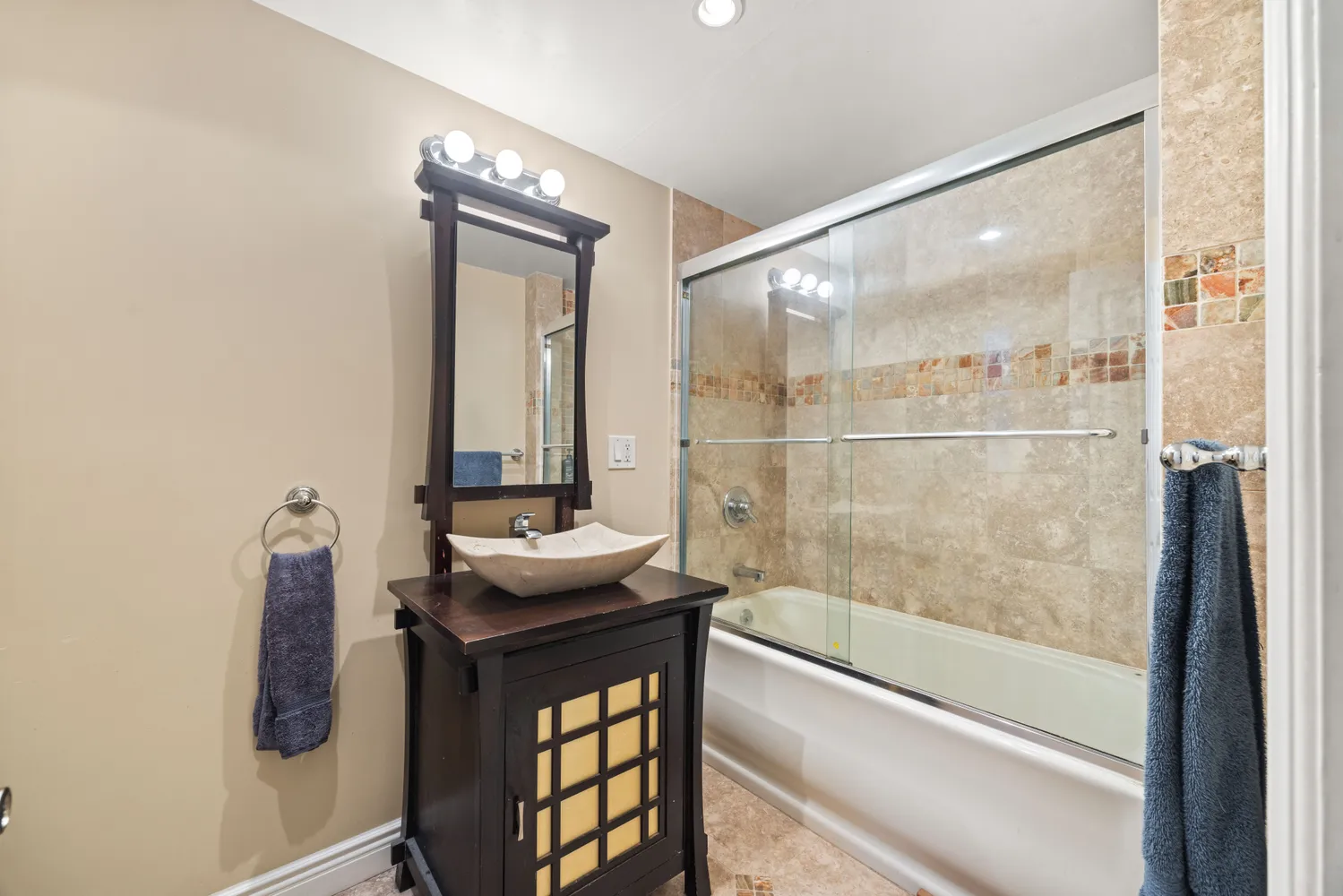 a bathroom with a granite countertop sink a mirror and shower