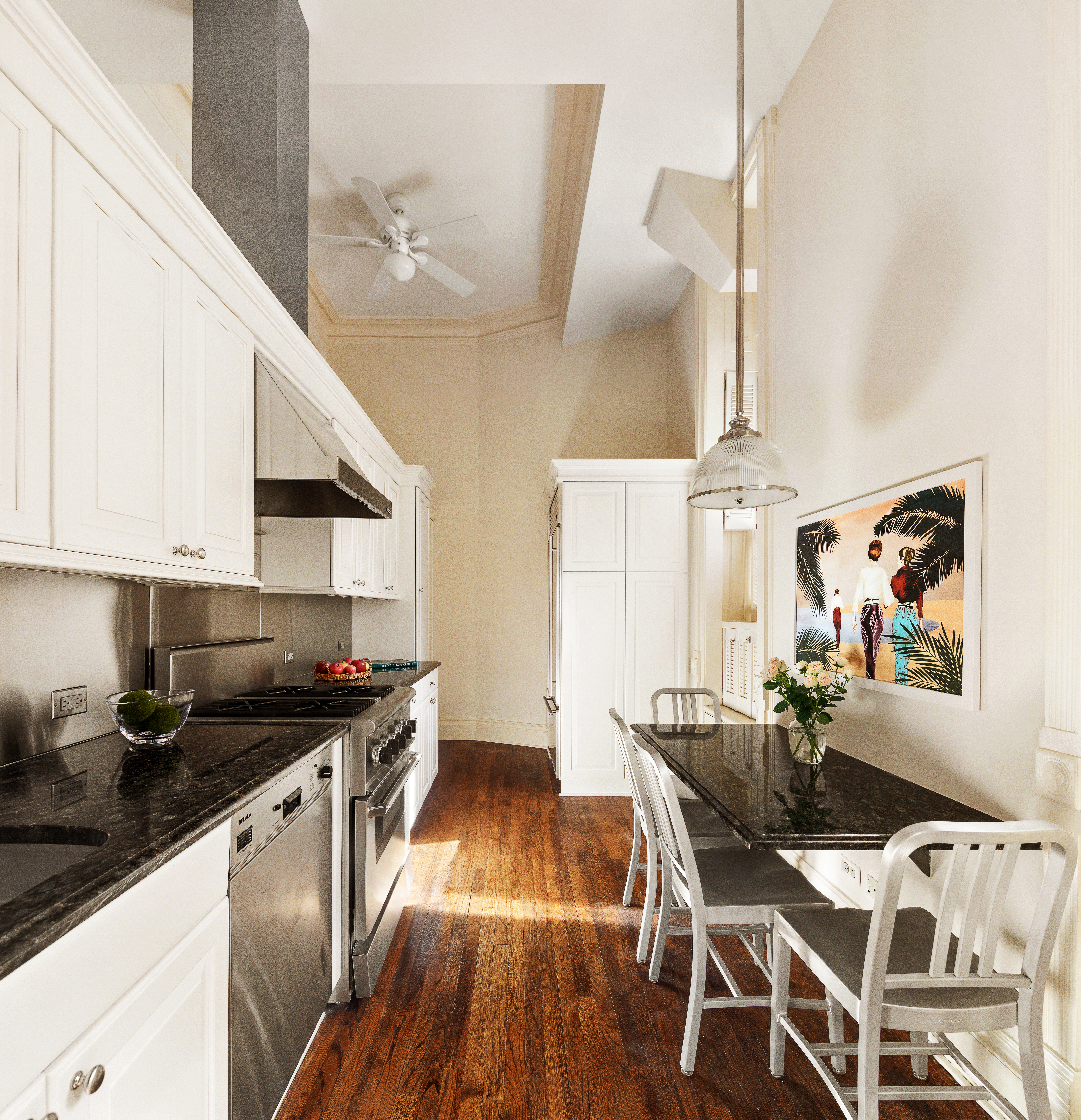 34 Gramercy Park East, Unit MAF Manhattan, NY 10010 - Photo 10 of 17 a kitchen with granite countertop a dining table chairs and white cabinets