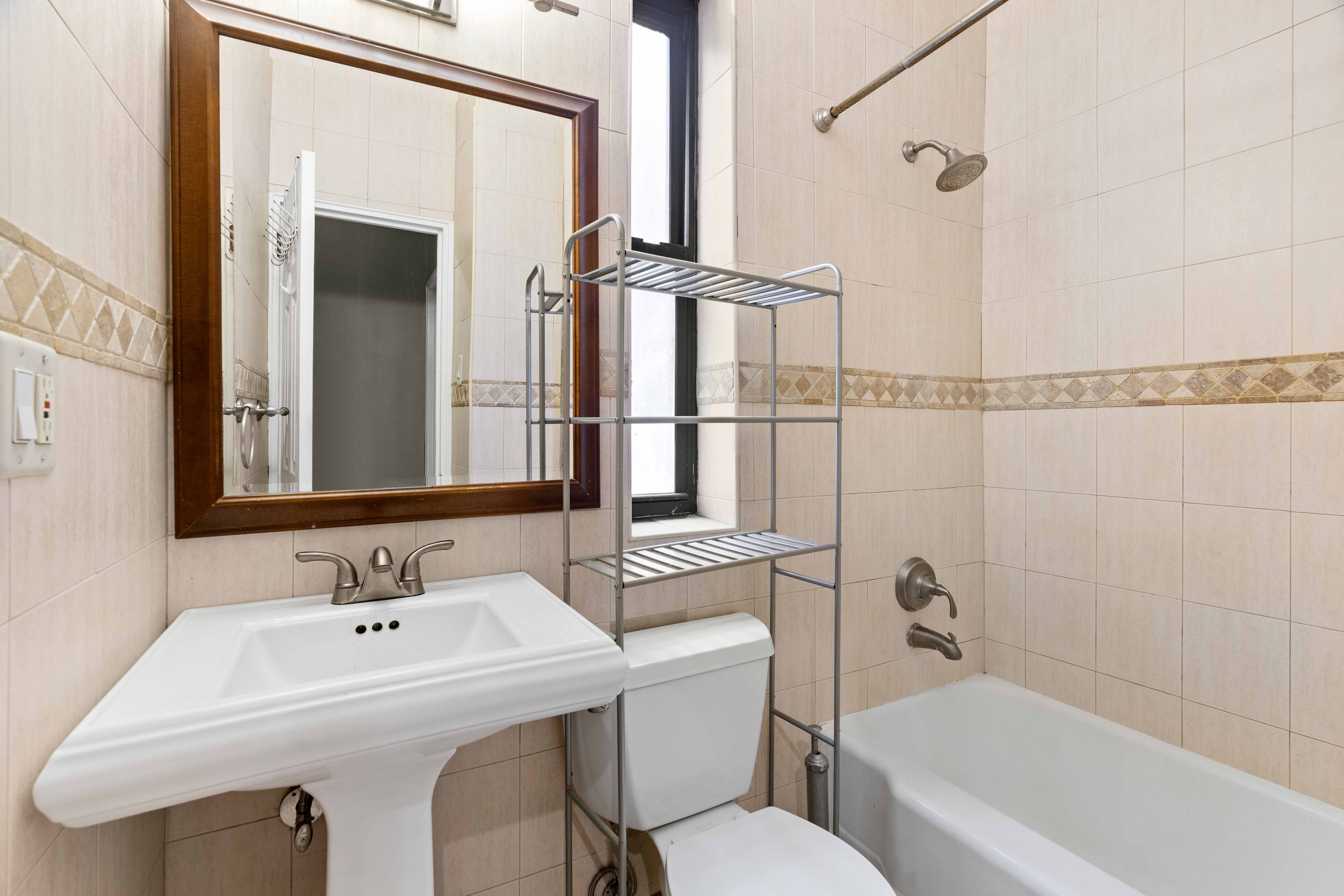 348 West 56th Street, Unit 5B Manhattan, NY 10019 - Photo 4 of 4 a bathroom with a sink a toilet and shower