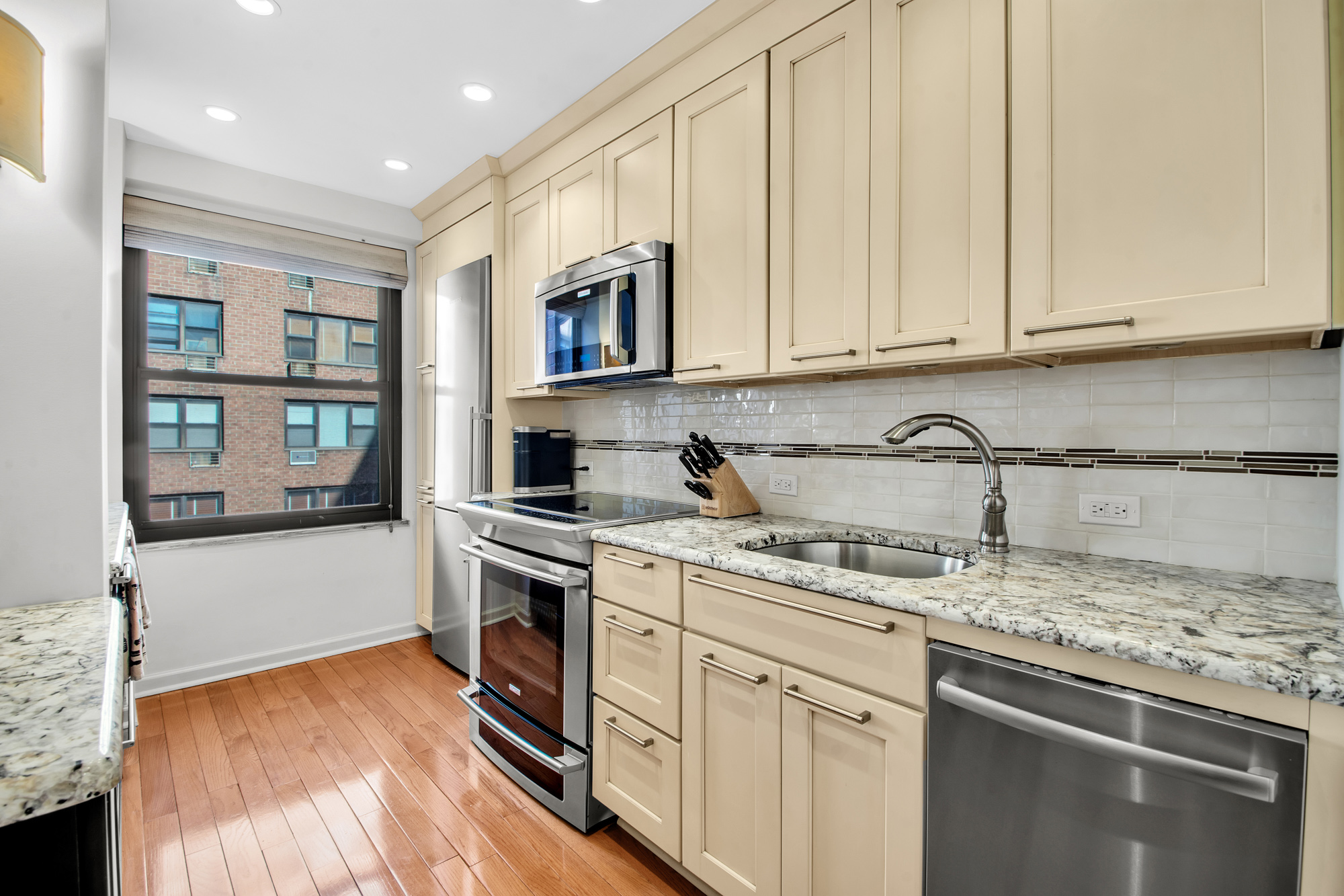 2 Tudor City Place, Unit 7FS Manhattan, NY 10017 - Photo 2 of 9 a kitchen with stainless steel appliances granite countertop a stove a sink and a microwave