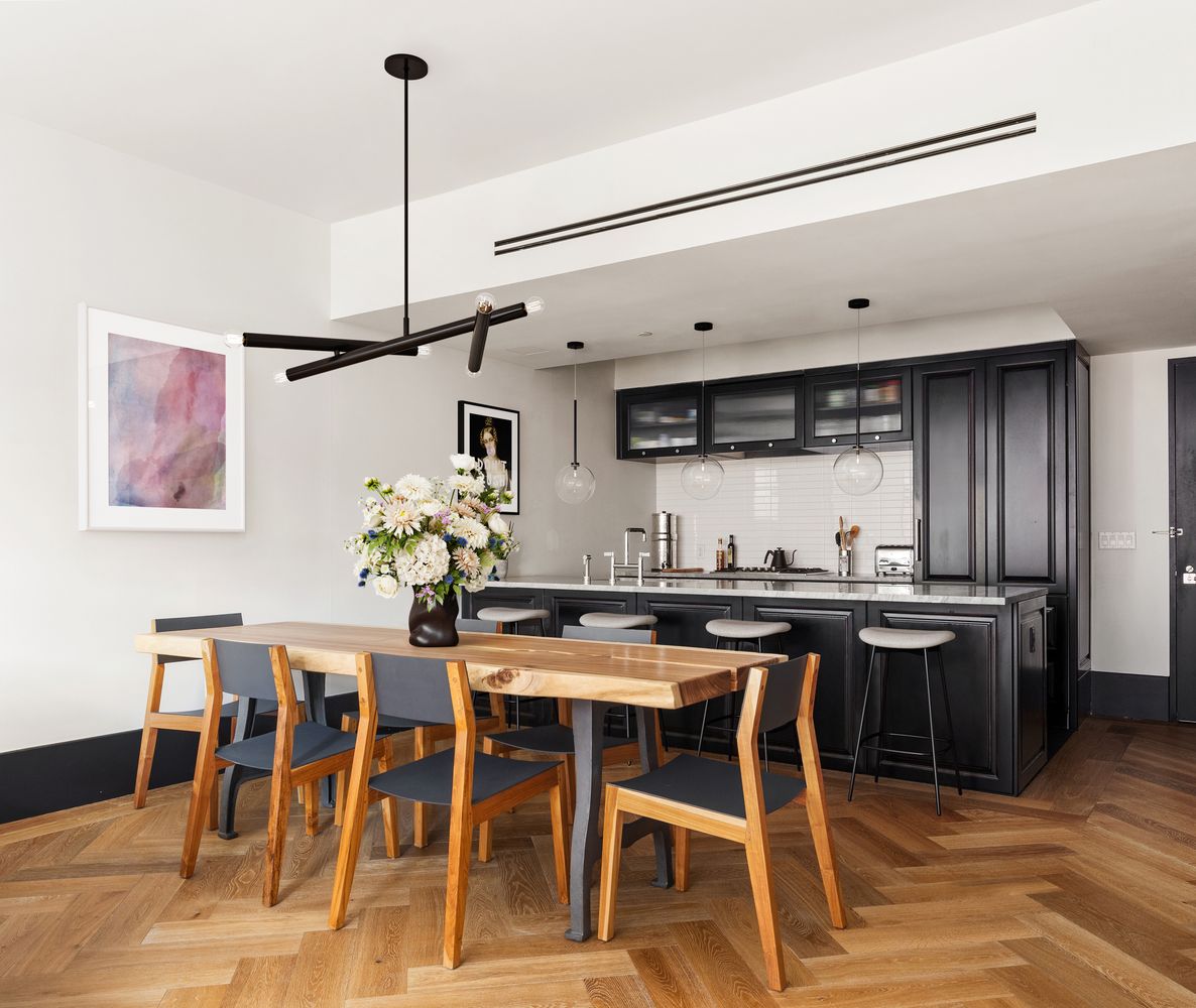 a kitchen with stainless steel appliances kitchen island granite countertop a table chairs and white cabinets