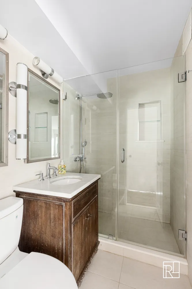 a bathroom with a sink a toilet and shower