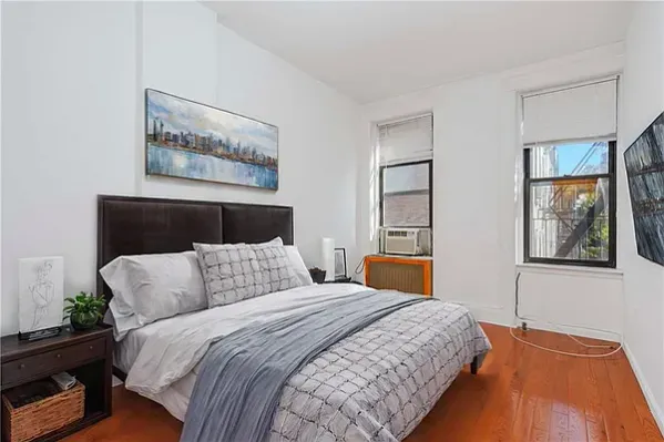 a bedroom with a large bed and a painting on the wall