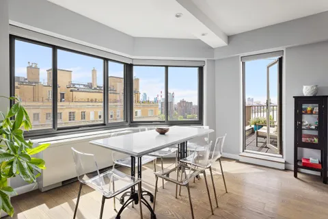 a dining room with furniture and large windows