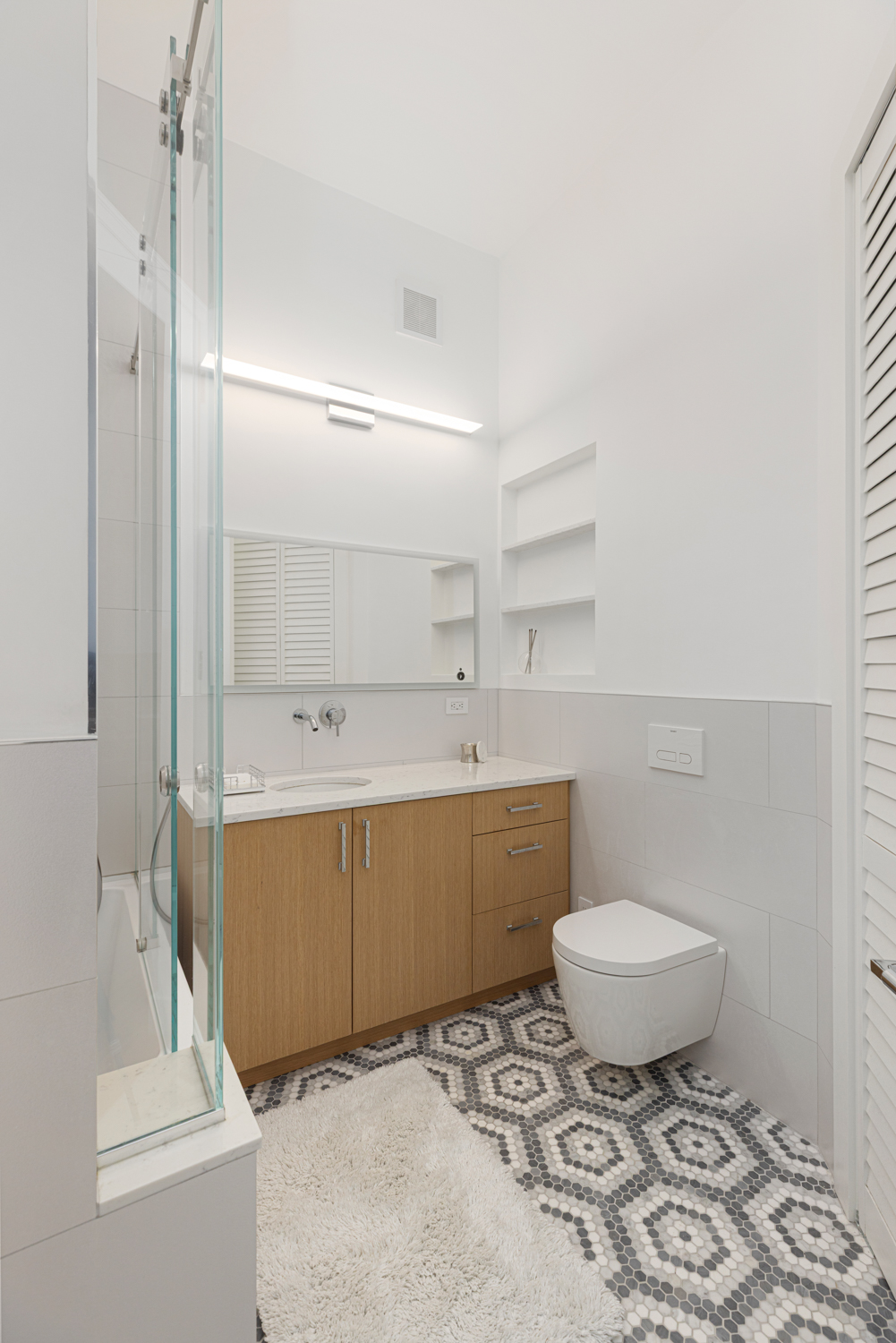 395 Broadway, Unit 5B Manhattan, NY 10013 - Photo 7 of 13 a bathroom with a sink toilet and shower