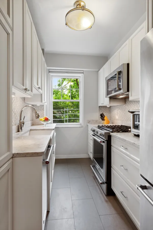 a kitchen with stainless steel appliances granite countertop a sink stove and cabinets