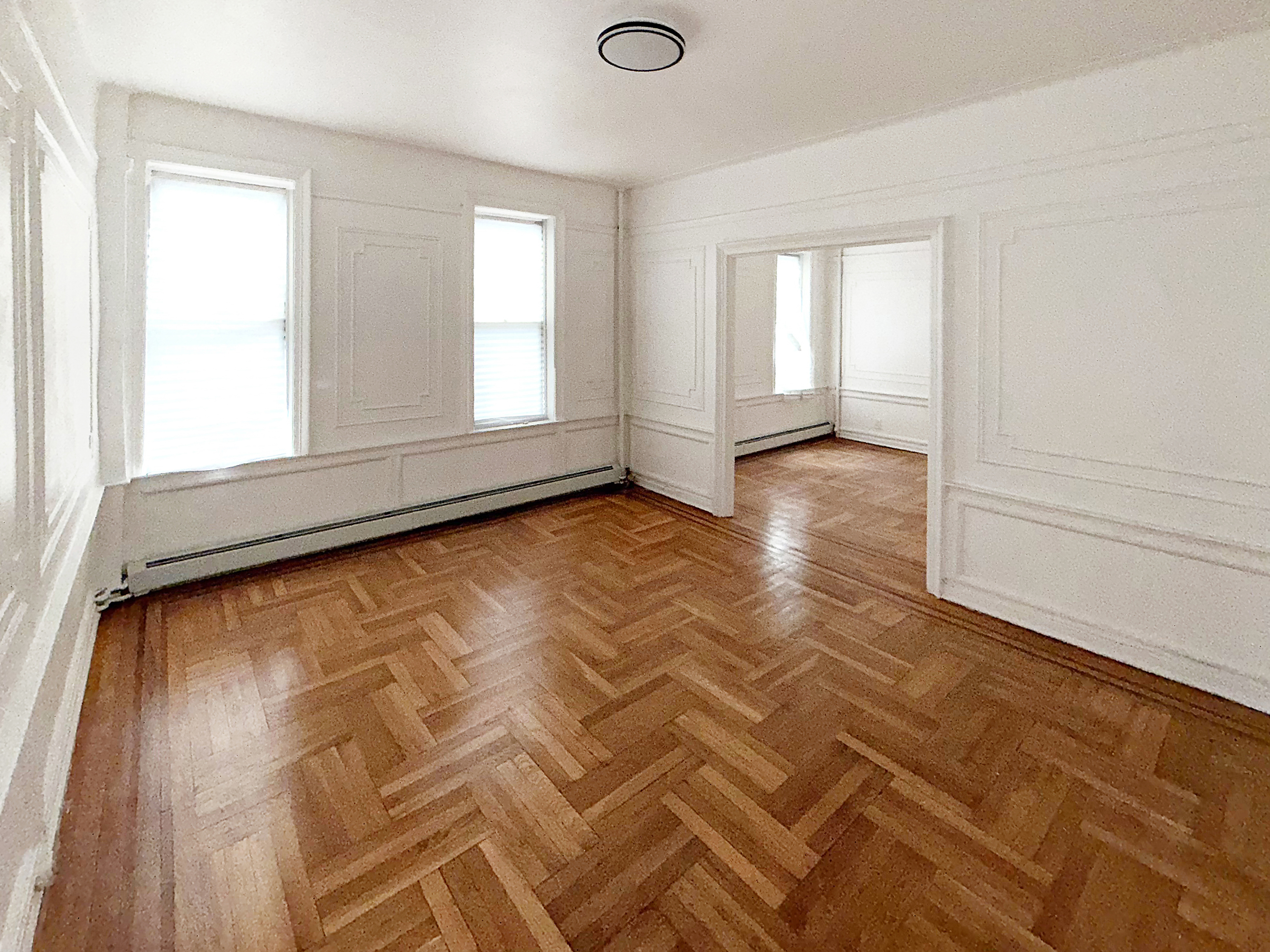 319 East 49th Street, Unit 1 Brooklyn, NY 11203 - Photo 3 of 8 a view of empty room with wooden floor and fan