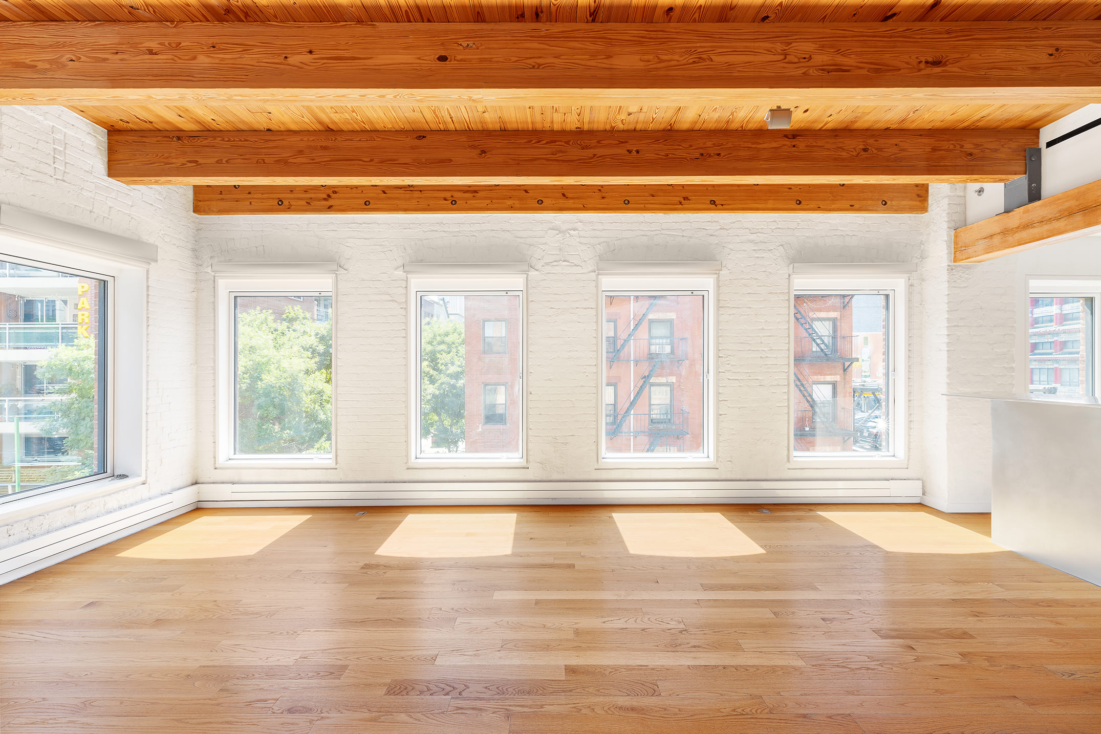136 Baxter Street, Unit 3C Manhattan, NY 10013 - Photo 3 of 15 a view of empty room with wooden floor and fan
