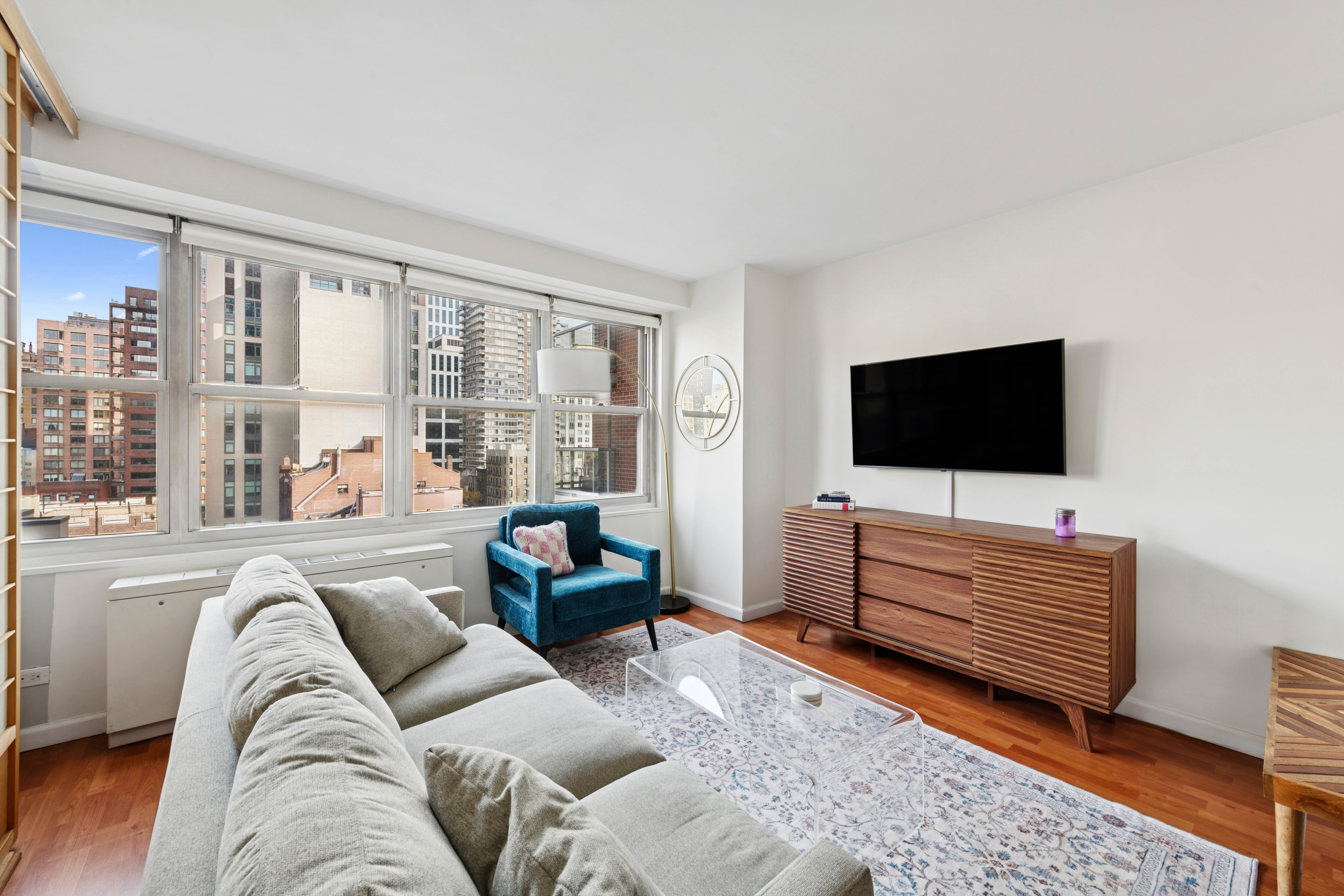 363 East 76th Street, Unit 11K Manhattan, NY 10021 - Photo 6 of 16 a living room with furniture and a flat screen tv
