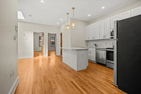 a view of a kitchen with wooden floor and a window