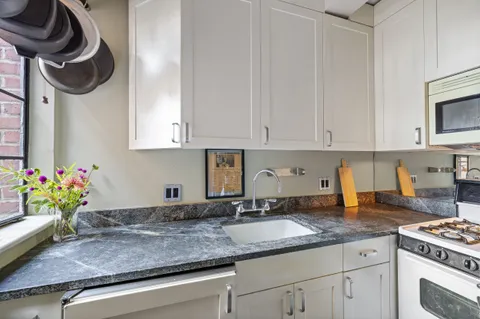 a kitchen with stainless steel appliances granite countertop a sink and a stove